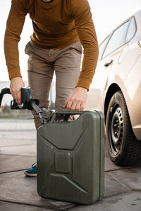 Man refilling canister with fuel on the petrol station. close up view. gasoline, diesel 