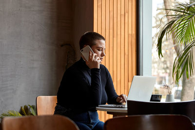 Businesswoman talking on phone while sitting at cafe