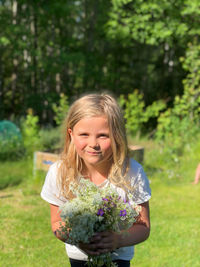 Portrait of a smiling girl standing against plants