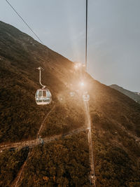 Overhead cable car on mountain road against sky