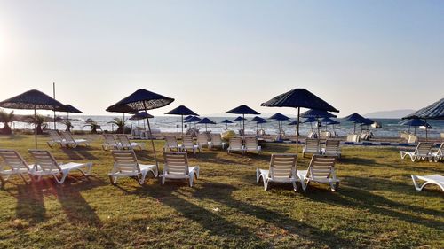 Chairs on beach against clear sky