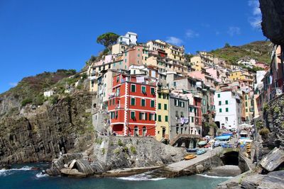 Buildings by mountain against clear blue sky