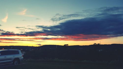 Landscape against cloudy sky at sunset