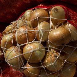Close-up of onions in sack for sale at market
