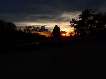 Silhouette trees on landscape against sky during sunset