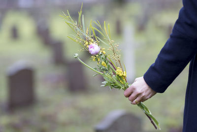 Hand with flowers on graveyard, skogskyrkogarden, stockholm, sweden