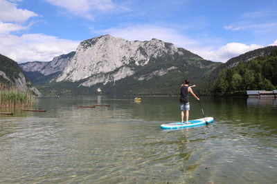 Man in boat on lake against mountains