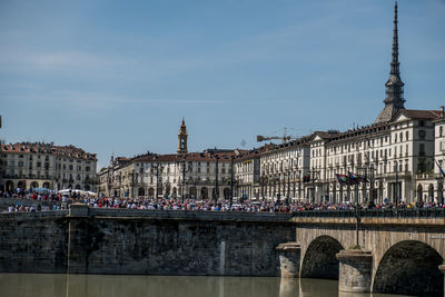 Bridge over river against buildings in city