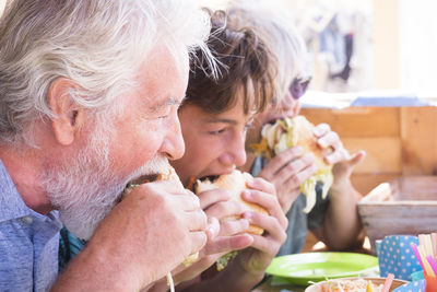 Family eating burgers at restaurant