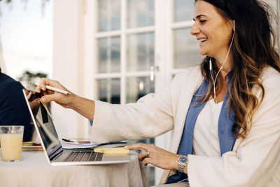 Woman using phone while sitting on table