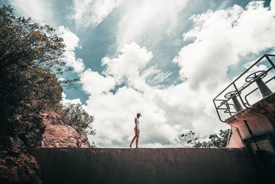 Low angle view of woman standing against sky