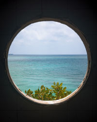 Scenic view of sea against sky seen through window