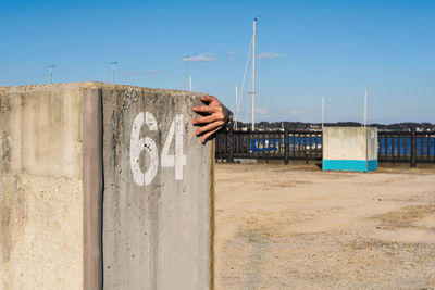 Person hiding behind concrete block at commercial dock