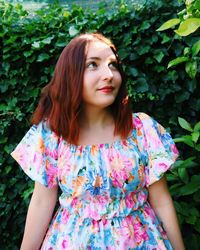 Portrait of beautiful woman standing against plants