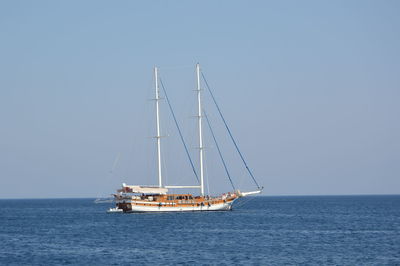 Sailboat sailing on sea against clear sky