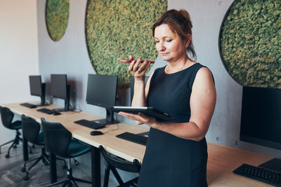 Businesswoman having business call working on tablet in office. mature busy woman using technology