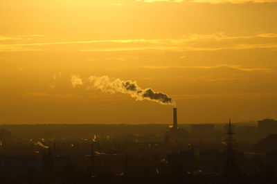 Smoke emitting from chimney at sunset