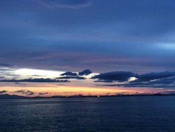 Scenic view of sea against dramatic sky during sunset