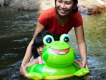 Happy mother with daughter swimming in river