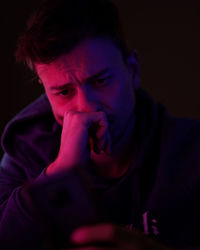 Close-up portrait of young man against black background. neon colors. punk colors. 