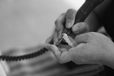 Cropped hands of dentist holding braces