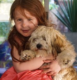 Portrait of cute girl with dog at home