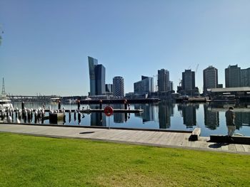 City by river and buildings against sky
