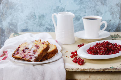 High angle view of red currants with cake slices on table