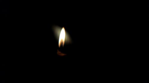 Close-up of lit candle in dark room