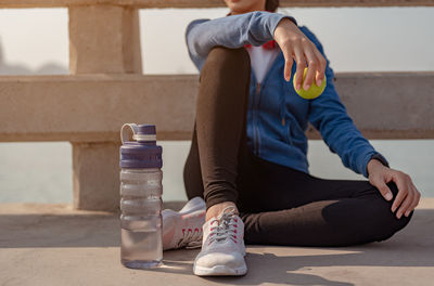 Low section of woman sitting outdoors