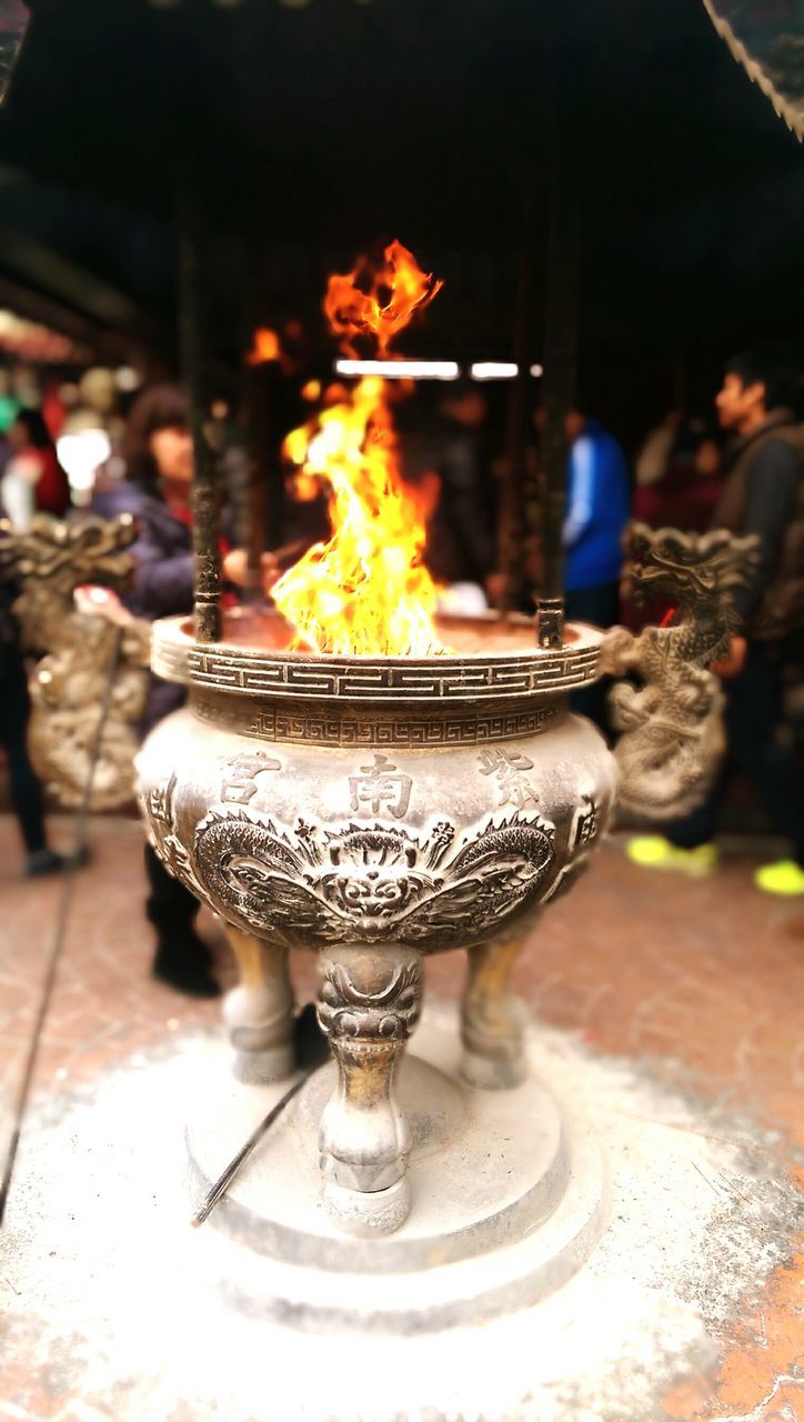 burning, flame, fire - natural phenomenon, candle, heat - temperature, illuminated, indoors, glowing, close-up, focus on foreground, night, lit, fire, religion, table, candlelight, place of worship, motion, selective focus, spirituality