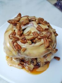 High angle view of pecan nuts on cinnamon roll in plate
