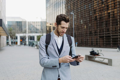 Young man using mobile phone in city