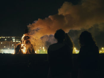 Rear view of silhouette people against sky at night