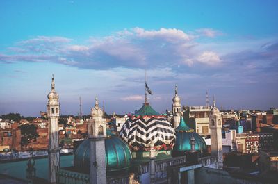 Historical buildings in city against cloudy sky