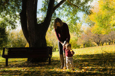 Rear view of man standing on bench in park