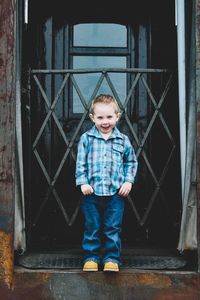 Portrait of boy standing against wall