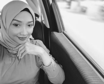 Portrait of a smiling young woman in car