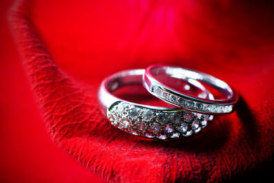 Close-up of wedding rings on red petal