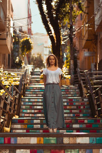 Woman standing on steps with tiptoe against building in city