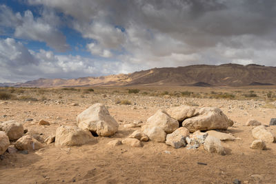 Rocks on arid landscape against sky
