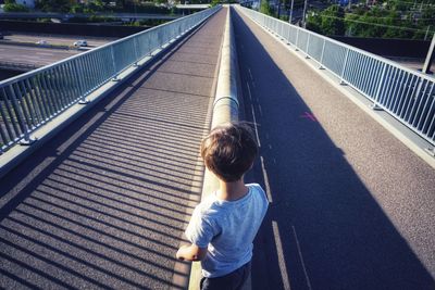 Rear view of girl on footbridge