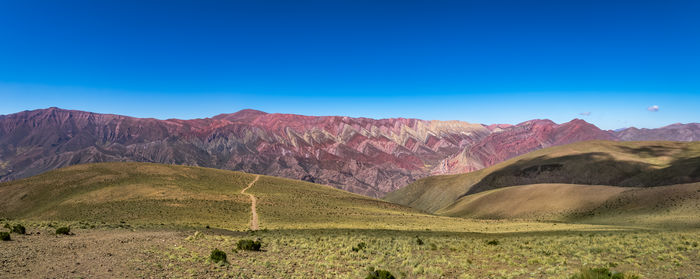 Scenic view of mountains against clear blue sky