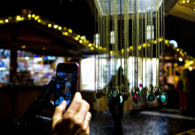 People photographing illuminated smart phone at night