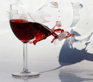 Close-up of wine spilling from broken glass
