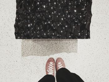 Low section of woman standing on tiled floor