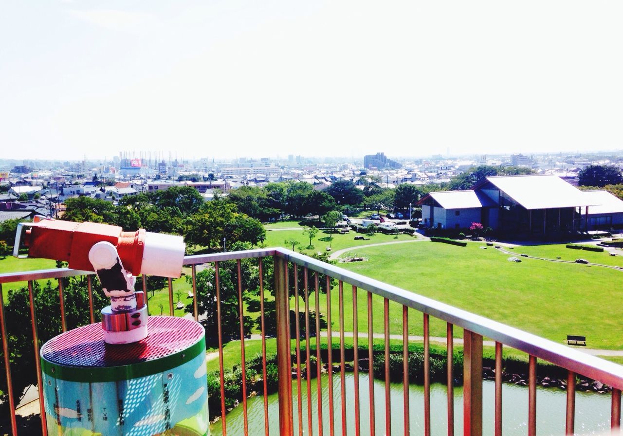 building exterior, architecture, built structure, clear sky, grass, sky, cityscape, city, high angle view, chair, copy space, day, residential building, house, residential structure, outdoors, sea, roof, landscape, horizon over water