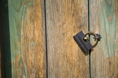 Close-up of padlock on wooden door