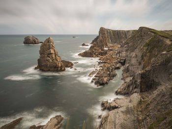 Scenic view of rocks in sea against sky