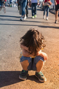 Rear view of boy on street in city